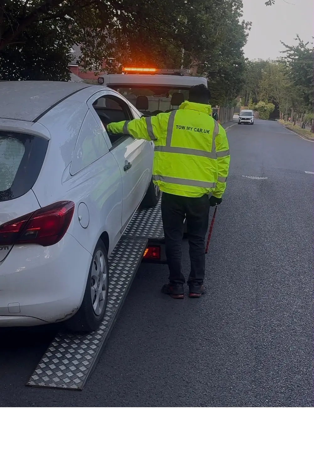 Breakdown service near me — TOW MY CAR recovery driver loading a broken-down car onto a flatbed truck for 24/7 roadside breakdown assistance in the UK